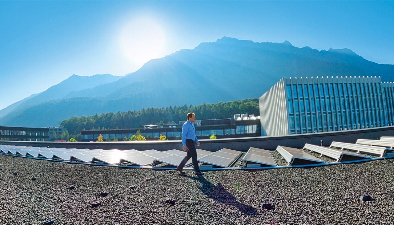 Un collaborateur Hilti marche sur un toit équipé de panneaux solaires
